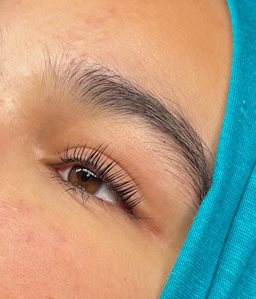 Close-up van een oog na een Korean lashlift, met verzorgde wenkbrauw